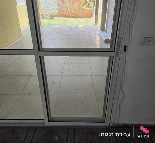 דלת זכוכית עם נוף לחצר מרוצפת